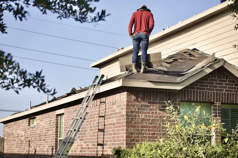 Professional roofer working on a residential roof in Franklin Village